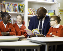 Pupils with headteacher reading