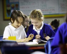 Two children working together with a book