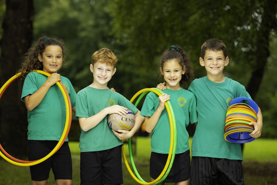Four primary pupils with sports equipment